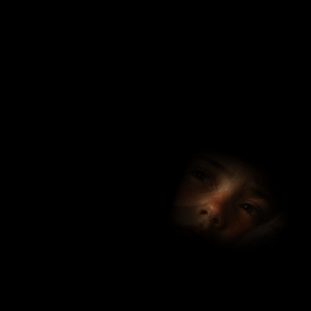 En un campo negro apenas se distingue el rostro de un niño febril.